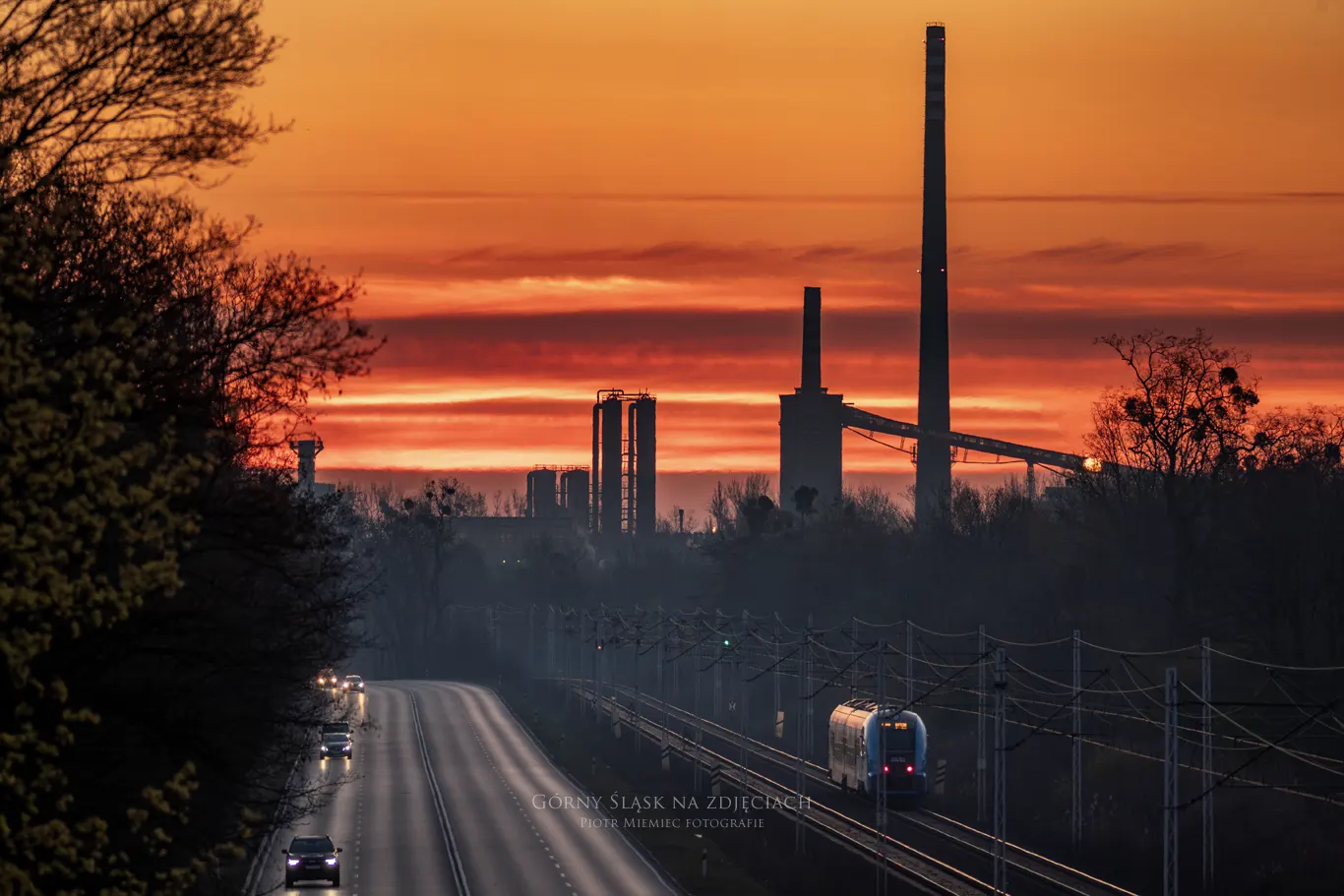 Wchód słońca nad drogą DK88 w Zabrzu, koksownia Jadwiga i przejeżdżający pociąg.